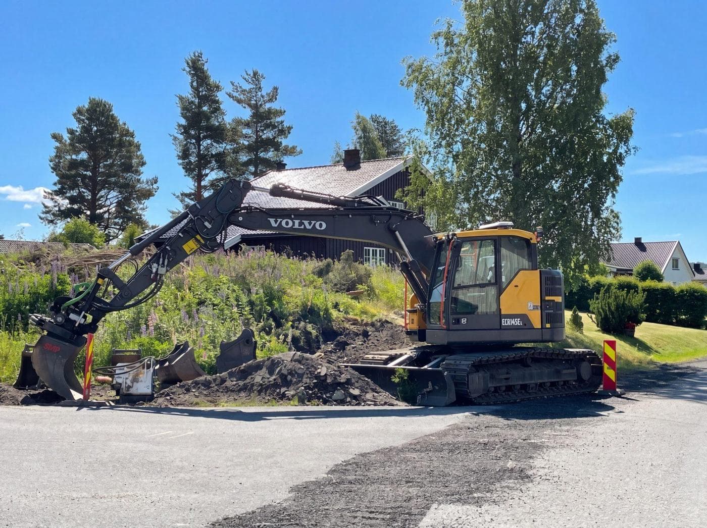 Gravemaskin i arbeid i boligstrøk