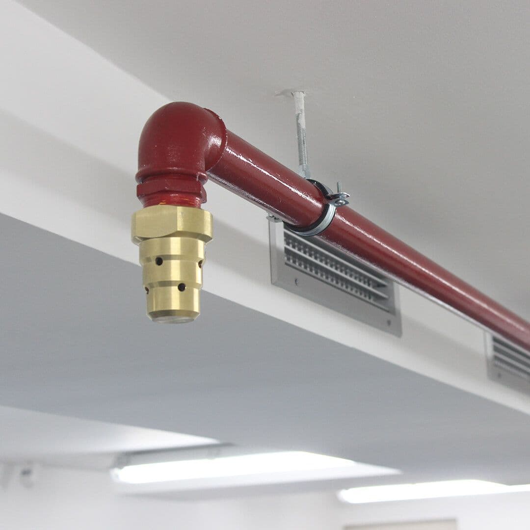 Sprinkleranlegg med rødt rør og sprinklerhode