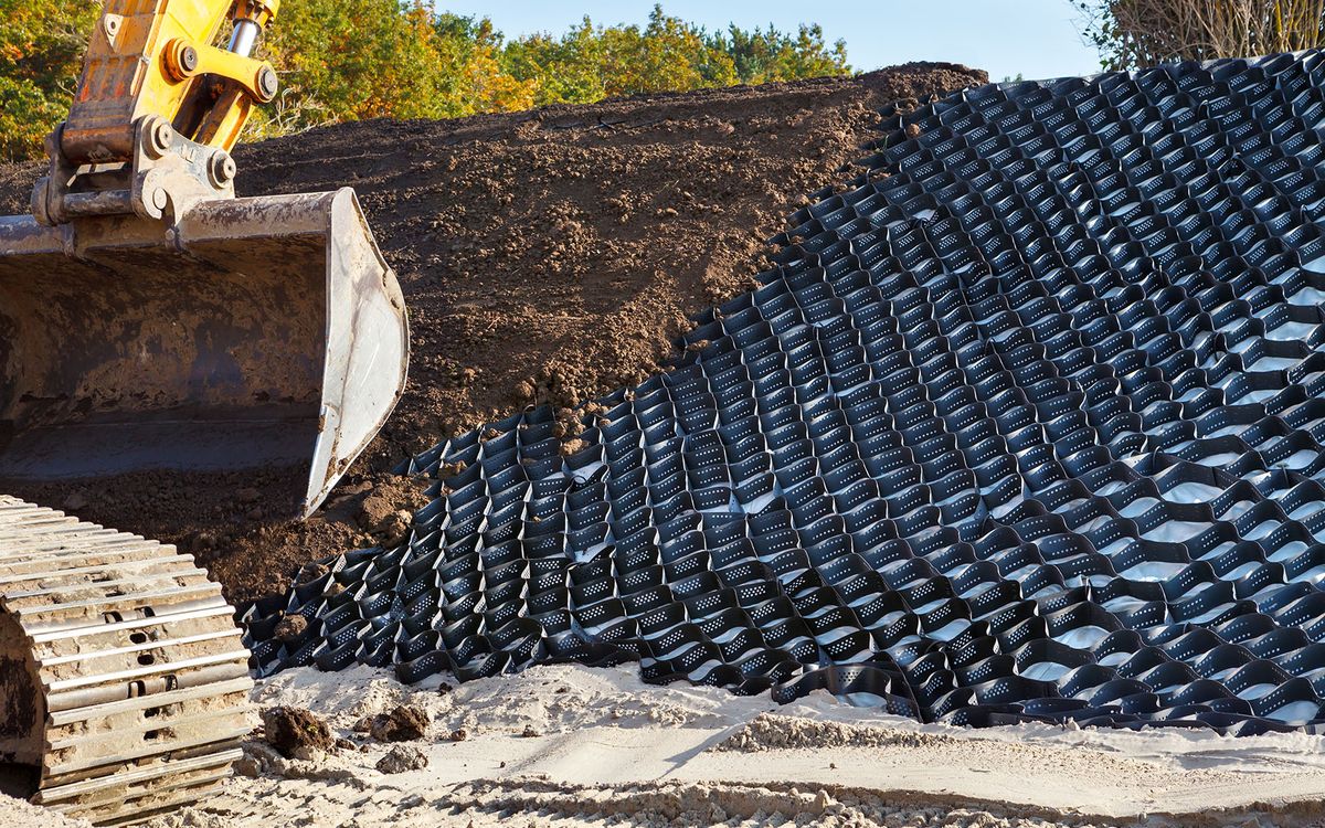 Gravemaskin legger geoceller i skråning